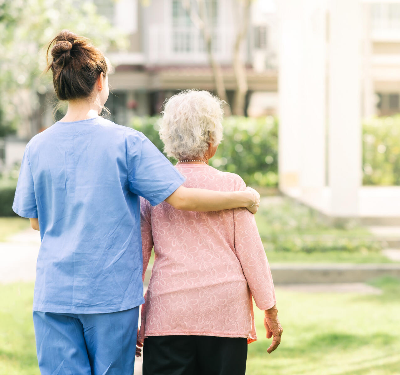 End-of-life doula Ontario End-of-life doula Ontario - backside of two individuals, one appearing to be a caregiver, with their arm wrapped around the other individuals back.