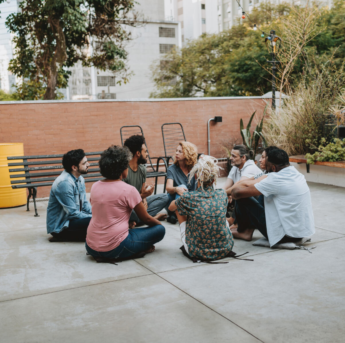 Legacy projects and end-of-life transitions in Ontario Support for Community Groups - A group of people sit on the ground in a circle, legs crossed, in discussion.
